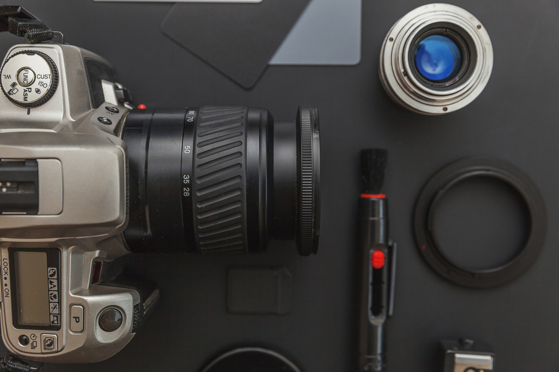 Photographer workplace with dslr camera system, camera cleaning kit, lens and camera accessory on dark black table background. Hobby travel photography concept Flat lay top view copy space